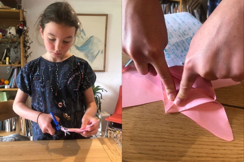 Una ragazzina che realizza un gioco per gatti origami