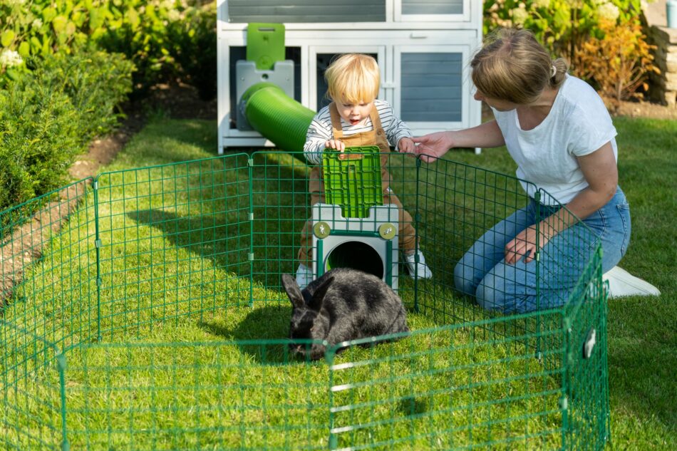 Proprietaria di conigli e il suo bambino con il loro coniglio che utilizza un sistema di tunnel Zippi di Omlet 
